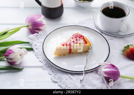 Veganer Käsekuchen mit Erdbeersoße und geriebener Reismilch, weißer Schokolade Stockfoto