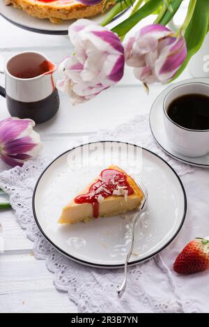 Veganer Käsekuchen mit Erdbeersoße und weißer, geriebener Reismilch-Schokolade Stockfoto