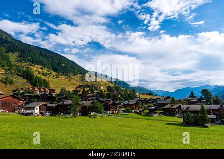 Alte traditionelle Schweizer Holzkörner und Chalets auf Steinpfählen in einem alten verlassenen Dorf in der Schweiz in den Bergen Stockfoto