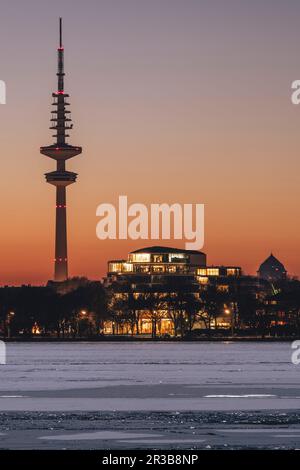 Deutschland, Hamburg, Eislauf in der Alster in der Dämmerung mit Heinrich-Hertz-Turm im Hintergrund Stockfoto