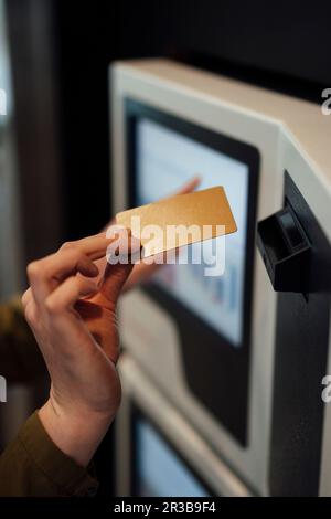 Frau, die eine Kreditkarte in den Geldautomaten einsteckt Stockfoto