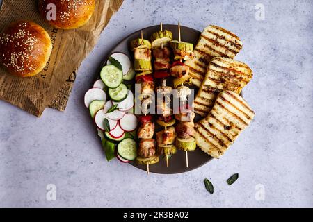 Hähnchenspieße mit gegrilltem Halloumi-Käse und frischem Salat Stockfoto