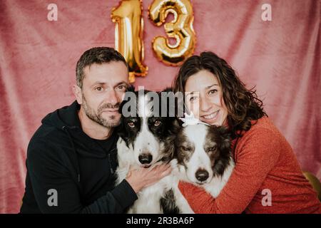 Glückliches Paar, das Border Collie Dogs umarmt Stockfoto