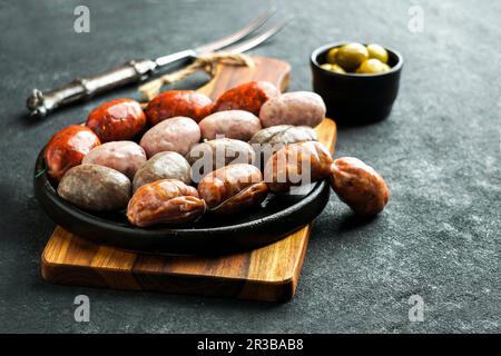 Spanische Würste auf dem Schneidebrett (Butifarra blanca, Chorizo, Morcilla de cebolla) Stockfoto