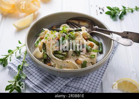 Tagliatelle in einer Cashew-Nusscreme mit gegrilltem grünen Spargel und geräuchertem Tofu Stockfoto