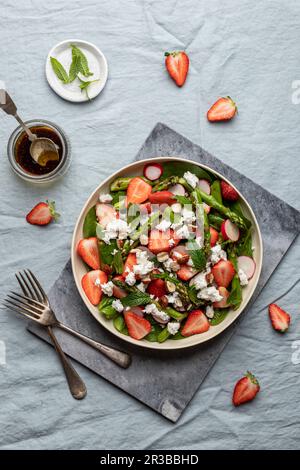 Salat aus gegrilltem Spargel, Erdbeeren, Baby-Spinat, Radieschen, frischer Minze, Fetakäse und Haselnüsse Stockfoto