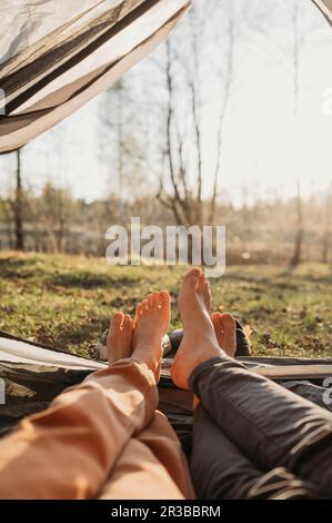 Ein Paar, das sich an einem sonnigen Tag im Zelt entspannt Stockfoto