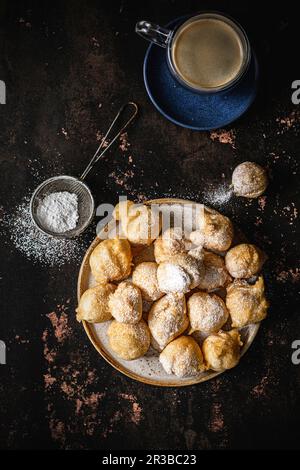 Mini-Donuts mit Puderzucker und einer Tasse Kaffee Stockfoto