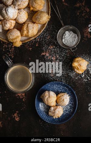 Mini-Donuts mit Puderzucker und einer Tasse Kaffee Stockfoto