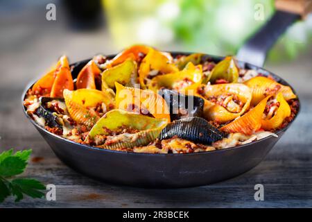 Farbenfrohe Conchiglioni arlecchino mit Bolognese-Sauce Stockfoto