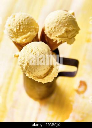 Drei Eiskegel mit Mango-Eis in einem Metallbecher Stockfoto