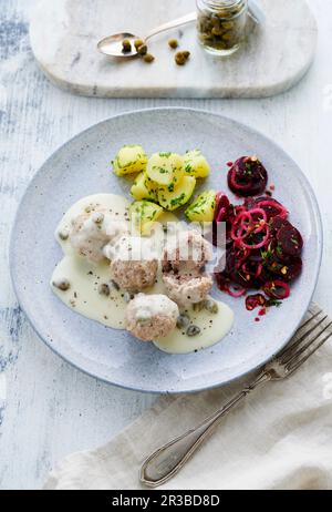 Königsberger Klopse (Fleischbällchen in weißer Sauce mit Kapern) mit gesalzenen Kartoffeln und einem Rote-Bete-Salat Stockfoto