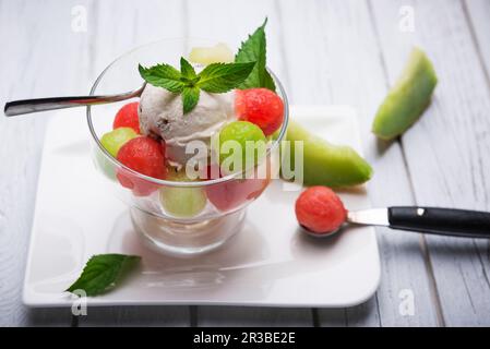 Vegane Bananeneis mit Walnüssen und Schokoladenchips auf Melonenbällchen Stockfoto