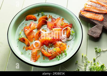 Wildlachs mariniert in Rote-Bete-Saft mit Aprikosenkeilen und Lachskaviar Stockfoto