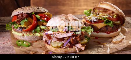 Drei verschiedene Hamburger auf Papier Stockfoto