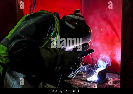 Man-Metallschweißen in einer Werkstatt Stockfoto