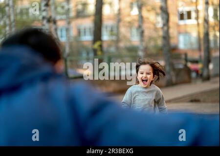 Aufgeregter Sohn, der im Park auf den Vater zugeht Stockfoto