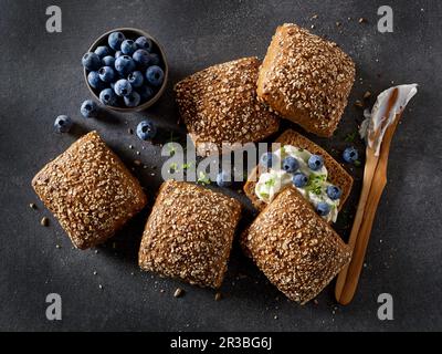Mehrkörnige Brötchen mit Frischkäse und Blaubeeren Stockfoto