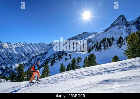 Österreich, Tirol, die Sonne scheint über der Skierin am Torhelm Berg Stockfoto