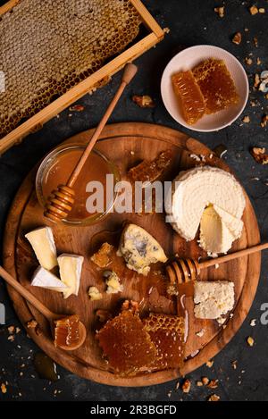 Käseplatte mit Ricotta, Camembert, Blauschimmelkäse, Nüssen und Honig Stockfoto