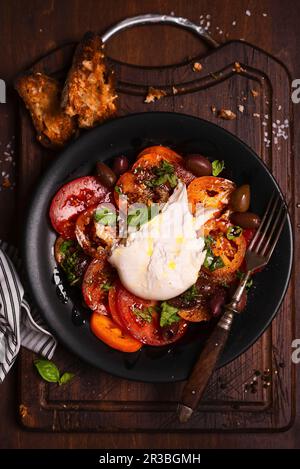 Roter und gelber Tomatensalat mit Burrata, Basilikum und Balsamessig Stockfoto