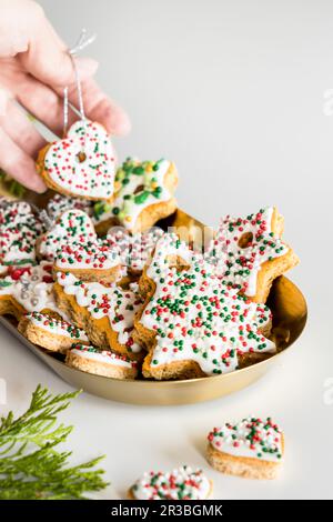 Lebkekse, dekoriert mit Weihnachtszuckerstreuseln und königlichen Glaswaren Stockfoto