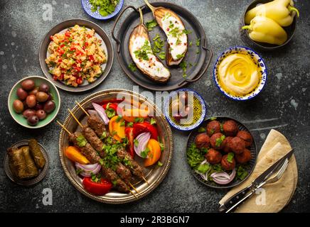 Nahöstliches Abendessen mit gegrilltem Kebab, Falafel, geröstetem und frischem Gemüse Stockfoto