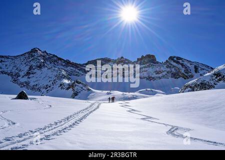 Österreich, Tirol, die Sonne scheint über Skifahrern, die durch den Schnee in Hollensteinkar reisen Stockfoto