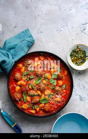 Tomatensuppe mit Fleischbällchen und Gnocchi mit Basilikum-Pesto Stockfoto
