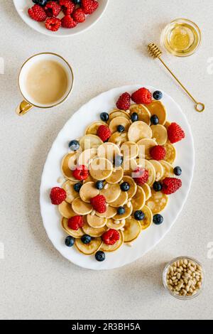 Mini-Pfannkuchen mit Beeren, Pinienkernen und Agavesirup Stockfoto