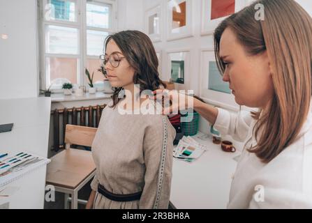 Modedesigner misst den Kunden in der Werkstatt Stockfoto