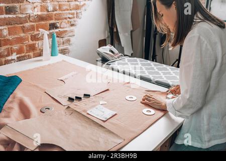 Modedesigner schneidet Stoff in der Werkstatt Stockfoto
