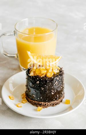 Schokoladenkuchen mit kandierten Orangenfrüchten und Saft Stockfoto