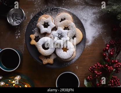 Frisch gebackene Linzer-Kekse, die mit Zucker gefüllt werden Stockfoto