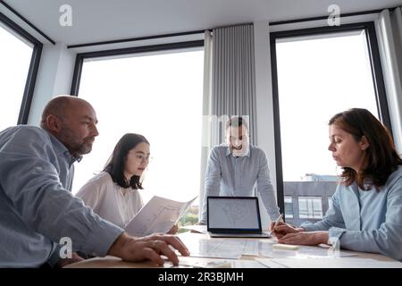 Geschäftsleute arbeiten gemeinsam an einem Architekturprojekt im Büro Stockfoto