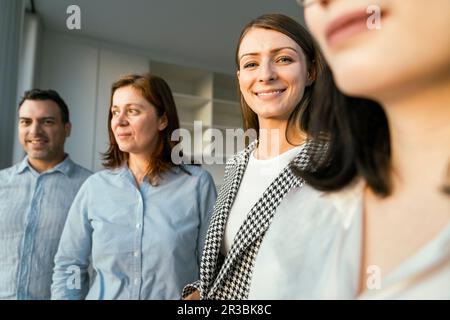 Porträt einer lächelnden Geschäftsfrau mit Kollegen im Büro Stockfoto