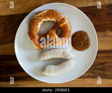 Weiße Würstchen mit süßem Senf und einer Brezel Stockfoto