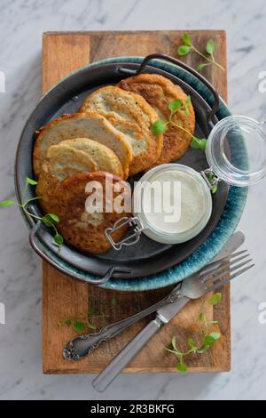 Kartoffel- und Zucchini-Pfannkuchen mit Joghurt-Sauce Stockfoto