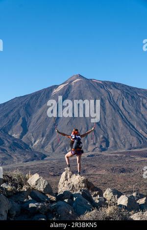 Frau mit Rucksackwanderung mit malerischem Blick auf den Sonnenaufgang am Morgen auf die einzigartige Felsformation Roque Cinchado, Roques de Garcia, Teneriffa, Kanarische Inseln Stockfoto