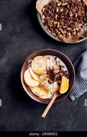 Eine Frühstückschüssel mit Joghurt, Apfel, Orange, Müsli, Honig und Zimt Stockfoto