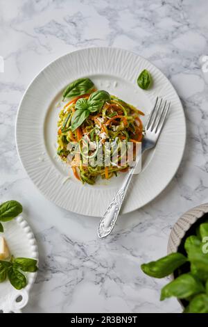 Rohe Zucchini und Karottennudeln mit Basilikum-Pesto-Sauce Stockfoto