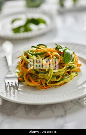 Rohe Zucchini und Karottennudeln mit Basilikum-Pesto-Sauce Stockfoto