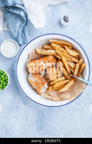 Fish and Chips – gebratener Kabeljau, pommes frites, grüne Erbsen und tatarsauce Stockfoto
