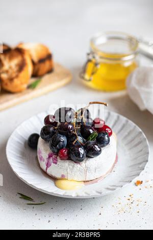Gebackener Camembert mit roten Trauben und Cranberrys Stockfoto