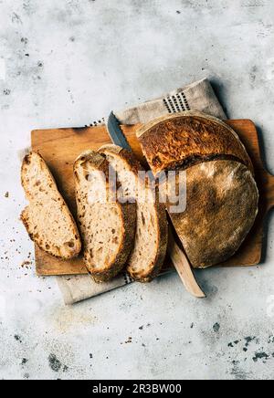 Dinkelteigbrot, auf einem Holzbrett geschnitten Stockfoto