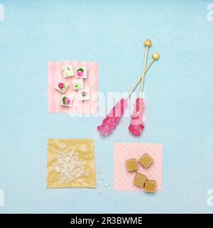 Zuckerstangen und Zuckerwürfel auf Papierquadraten Stockfoto