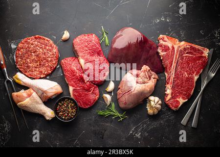 Auswahl an verschiedenen rohen Fleischgerichten mit Gewürzen Stockfoto