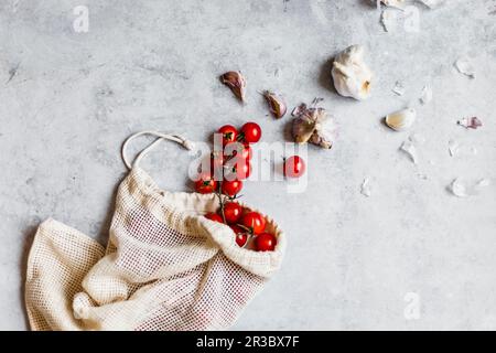 Nachhaltigkeit - Kirschtomaten und Knoblauch in einem Stoffbeutel Stockfoto