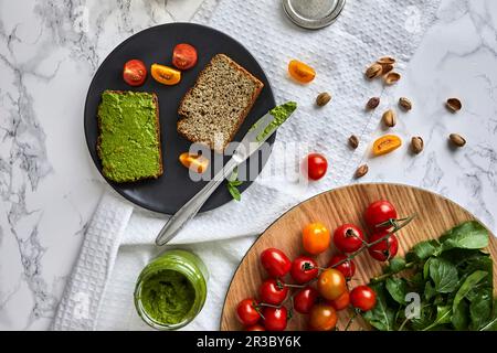 Hausgemachtes Basilikum und Rucola-Pesto auf einem Stück Brot Stockfoto