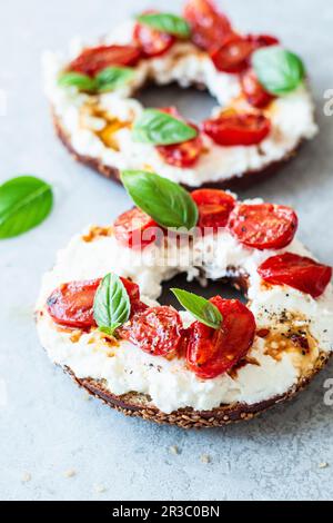 Frühstücks-Bagel mit Feta und gedünsteten Tomaten Stockfoto